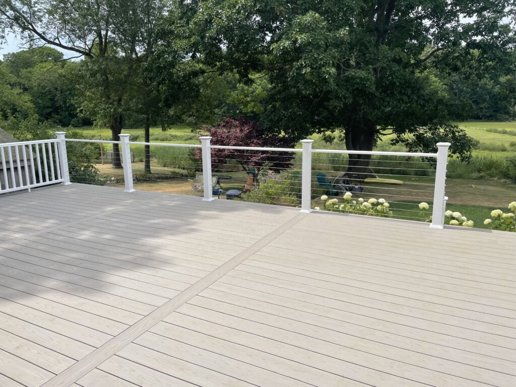 Expert deck builder installing composite backyard deck with railing
