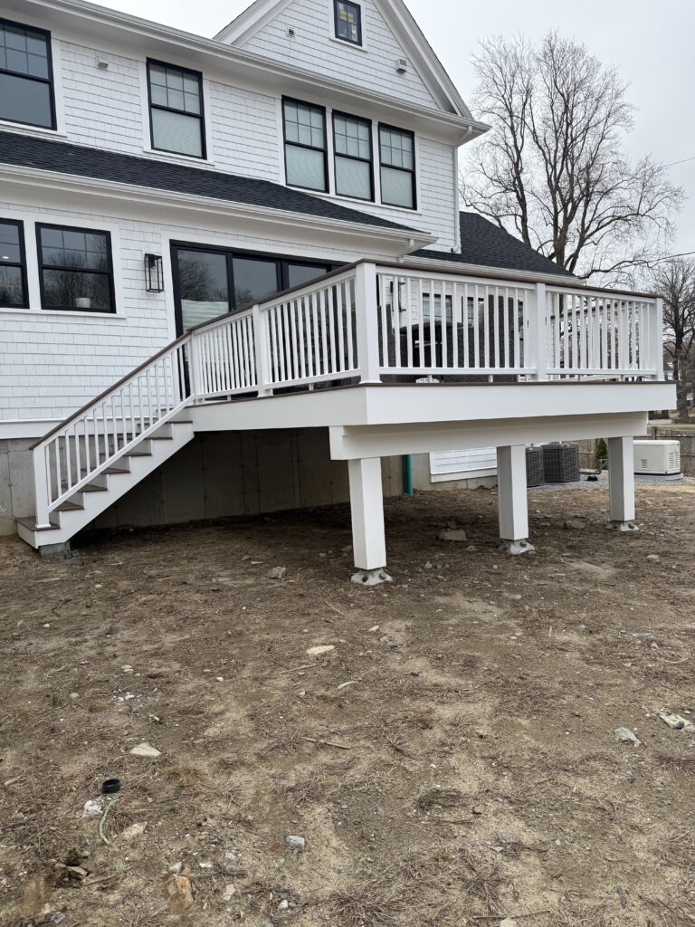 White house with elevated wooden deck.